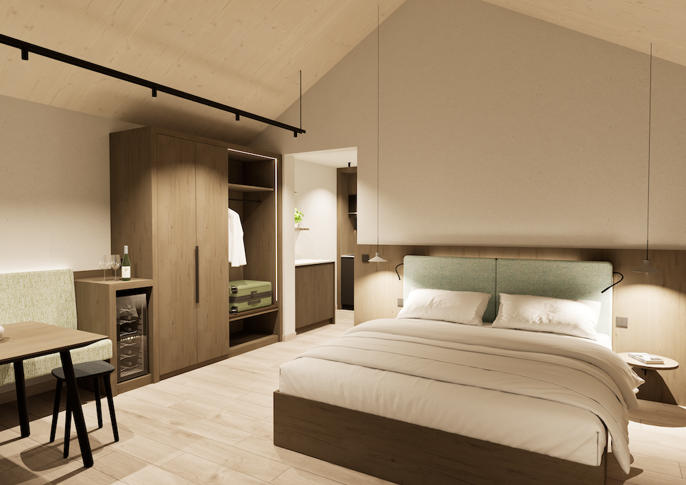 Ein modernes Zimmer im Winzerhaus verfügt über ein ordentlich gemachtes Doppelbett, Holzmöbel, einen offenen Kleiderschrank mit Kleidung und Koffer, einen kleinen Tisch mit Stühlen, einen Mini-Kühlschrank und eine sanfte Deckenbeleuchtung.